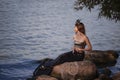 Mermaid Lady In Net At Sea Coast on Rocks Wearing Seashell Decorated Crown and Black Shiny Tail On Sexy Body Covered With Strasses