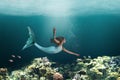 Underwater Mermaid Swimming Among Ocean Coral Reef