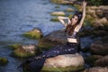 Mermaid Posing Near Ocean Shore on Rocks While Wearing Seashell Decorated Crown and Black Shiny Tail On Seductive Body Covered