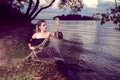 Mermaid Posing With Net Near Sea on Rocks While Wearing Artistic Makeup And Facial Strassses and Black Shiny Tail Covered With