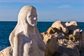 Mermaid sculpture carved out of the stone rocks at Piran harbor, Istria