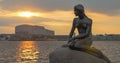 Mermaid statue on the stone in sea at sunset