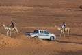 MEROE, SUDAN - MARCH 4, 2019: Locals ride camels near the pyramids of Meroe, Sud