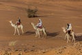 MEROE, SUDAN - MARCH 4, 2019: Locals riding camels near the pyramids of Meroe, Sud