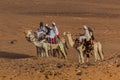 MEROE, SUDAN - MARCH 4, 2019: Locals riding camels near the pyramids of Meroe, Sud