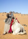 Sudanese young man with his camel in a desert