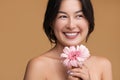 Merry Asian female with pink gerbera