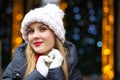 Merry blonde girl with red lipstick wearing knitted cap posing a