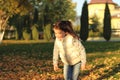 A merry child scatters an armful of yellow fallen leaves. Sunny sunset in autumn park outdoors Royalty Free Stock Photo