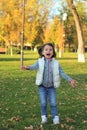 A merry child scatters an armful of yellow fallen leaves. Sunny sunset in autumn park outdoors Royalty Free Stock Photo