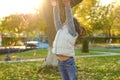 A merry child scatters an armful of yellow fallen leaves. Sunny sunset in autumn park outdoors