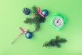 Merry Christmas, alarm clock, fir branches and toy balls on bright background