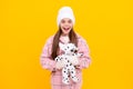 merry christmas. amazed kid in winter hat with toy. teen girl in mittens hold toy