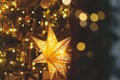 Merry Christmas! Atmospheric christmas eve. Stylish christmas illuminated star, christmas tree with golden lights in evening