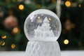 Merry Christmas! Atmospheric winter time. Stylish christmas snow globe on background of christmas tree in lights in festive Royalty Free Stock Photo