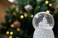 Merry Christmas! Atmospheric winter time. Stylish christmas snow globe on background of christmas tree in lights in festive Royalty Free Stock Photo