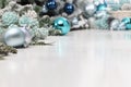 Merry christmas background, silver and blue christmas balls and pine cones decorations on white table, useful as a greeting card Royalty Free Stock Photo