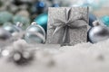 Merry christmas background, silver gift present box with bow and ribbon, next to blue Christmas balls and snowflakes, useful as a Royalty Free Stock Photo