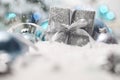 Merry christmas background, silver gift present box with bow and ribbon, next to blue Christmas balls and snowflakes, useful as a Royalty Free Stock Photo
