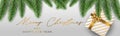 Merry Christmas banner or header. White present box with golden bow under green fir tree branches on silver background Royalty Free Stock Photo