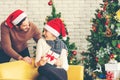 Merry Christmas. Boyfriend surprising his girlfriend with Christmas gift. Young couple celebrating and party and drinking champagn