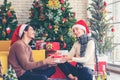 Merry Christmas. Boyfriend surprising his girlfriend with Christmas gift. Young couple celebrating and party and drinking champagn