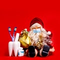 Merry Christmas Card From Dentist Tooth Model With Presents On Red Background With Copy Space.