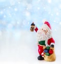 Merry christmas card with Santa Claus figurine. Lights background with space for text. Winter holidays. Xmas theme Royalty Free Stock Photo