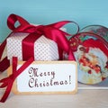 Merry Christmas Card with a Vintage Santa Candy Tin and Red and White Gift Present tied with a Red Satin Bow and a Tag with Holida