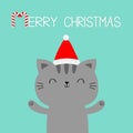 Merry Christmas. Cat holding hands up. Paw print. Red Santa Claus hat. Cartoon kawaii character. Cute face icon. Kitten kitty. Royalty Free Stock Photo