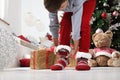 Merry christmas, child wears Christmas socks near the tree and gift packages with teddy bear