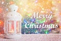 Merry Christmas. Christmas white lantern with a burning candle on the background of a Christmas tree, lights of garlands, bokeh. Royalty Free Stock Photo