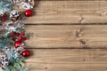 Merry Christmas composition. Fir branches with cones, berries and snow decorations on old dark wooden background with copy space Royalty Free Stock Photo