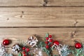 Merry Christmas composition. Fir branches with cones, berries and snow decorations on old dark wooden background with Royalty Free Stock Photo