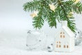 Christmas composition with green fir tree branch, star lights, toy house and balls against white background Royalty Free Stock Photo