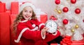 Merry christmas concept. Last minute till midnight. Waiting for miracle. New year countdown. Girl kid santa hat hold Royalty Free Stock Photo