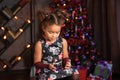 Merry Christmas! Cute little child girl is decorating the Christmas tree