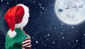 Merry Christmas. Cute little child looking at Santa Claus flying in his sleigh against moon sky. Royalty Free Stock Photo