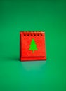 Merry Christmas day calendar with green Christmas tree minimal.graphic icon on red folding desk calendar.