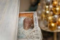 Merry Christmas decorated interior details. Drawer with shiny pine cone toy, pearl beads, artificial snow. Golden baubles,