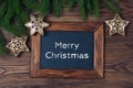 Merry Christmas decorations, chalkboard with text Merry Christmas and frame made of fir, snowflake and stars on a timber Royalty Free Stock Photo