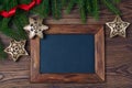 Merry Christmas decorations, empty chalkboard and frame made of red ribbon, fir, snowflake and stars on a timber background Royalty Free Stock Photo
