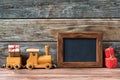Merry Christmas decorations, empty chalkboard with toy wooden train and christmas gifts on a timber background Royalty Free Stock Photo