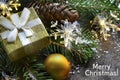 Merry Christmas.Festive decoration with fir tree,golden gift box,garland lights and pine cones on old wooden background. Royalty Free Stock Photo