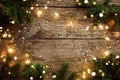 Merry Christmas frame made of Christmas decorations, fir branches, spruce, lights garland, snowflakes on wooden background. Xmas Royalty Free Stock Photo