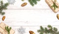 Merry Christmas frame and wallpaper. Happy New Year composition. Christmas gift, pine cones, fir branches on wooden white