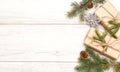 Merry Christmas frame and wallpaper. Happy New Year composition. Christmas gift, pine cones, fir branches on wooden white