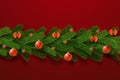 Merry Christmas garland, isolated red background. 3D green branch, holiday frame. Hanging decor. Invitation ornament Royalty Free Stock Photo