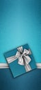 Merry christmas gift card, blue box with shiny silver ribbon bow isolated on turquoise glittering background, top view copy space Royalty Free Stock Photo