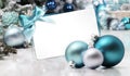 Merry christmas gift card with bow and ribbon, next to blue Christmas balls, useful as a greeting card template with copy space Royalty Free Stock Photo